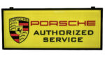 Porsche Authorized Service Light-Up Sign. Painted acrylic panel. 73”x31.5”. Black metal frame with mounting brackets. Front sign is bright yellow with Porsche Shield Logo on the left and the word PORSCHE in red with Authorized Service underneath in black. Sharp looking sign.