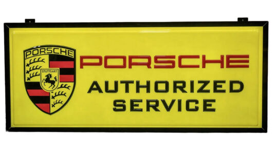 Porsche Authorized Service Light-Up Sign. Painted acrylic panel. 73”x31.5”. Black metal frame with mounting brackets. Front sign is bright yellow with Porsche Shield Logo on the left and the word PORSCHE in red with Authorized Service underneath in black. Sharp looking sign.