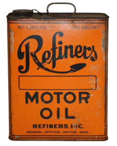Refiners Slim 1 Gallon Oil Can. A slim orange oil can with “Refiners MOTOR OIL” written in large black letters across the can. “REFINERS, INC” is written across the bottom with “GENERAL OFFICES, DAYTON, OHIO” written below. Some wear and rust.
