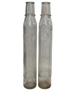 Group of 2 Tiolene Tall Glass Embossed 1 Quart Bulk Oil Bottles. Two tall, slender, clear glass bottles with “Tiolene Motor Oil” embossed across the center.