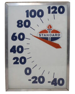 Standard Oil Advertising Thermometer. Rectangular thermometer in a silver frame. White sign with blue numbers with 120 at the top, descending by 120 to –40 at the bottom. The red and blue Standard Oil logo with a torch is featured under the numbers.
