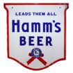 Hamm’s Large Double-Sided Porcelain “Leads them all Shield” Outdoor Sign – wow! White sign with red border and blue lettering. “LEADS THEM ALL” is written across the top with “Hamm’s Beer” written below. A blue and red ribbon is featured at the bottom with “Hamm St.Paul” written around an eagle graphic.