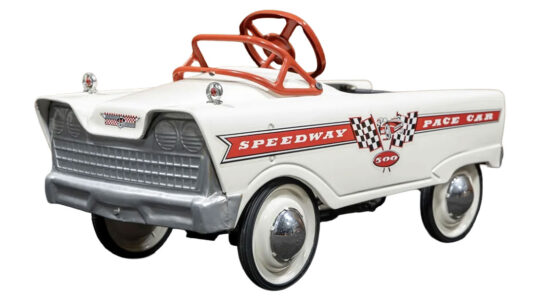 1960s Murray “Speedway Pace Car” Pedal Car. 36”x17”x17.5”. Arctic White with original style graphics, windshield frame in red, fender ornaments with red jewel reflectors, adjustable pedals, molded tires on white wheels with hubcaps, black padded vinyl seat.