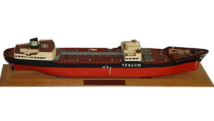 SS Texaco North Dakota Plastic Advertising Tanker Ship with Stand. A very intricate red and black tanker ship replica sitting on top of a brown wooden stand. “TEXACO” is written across the middle in large white letters with “TEXACO NORTH DAKOTA” written in smaller white letters on the left side.